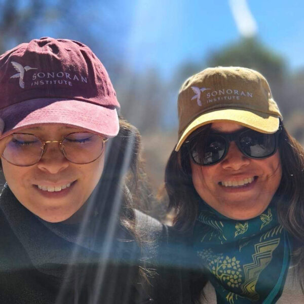 Two Sonoran Institute donors wearing their Sonoran Institute ball caps.