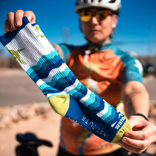 A biker holds a pair of our River Socks to display the water pattern.